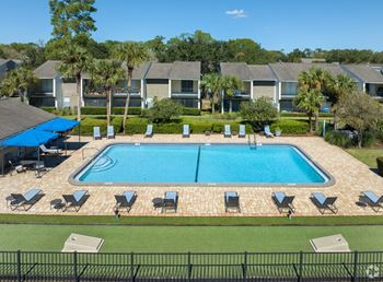 An aerial view of a swimming pool in front of an apartment building